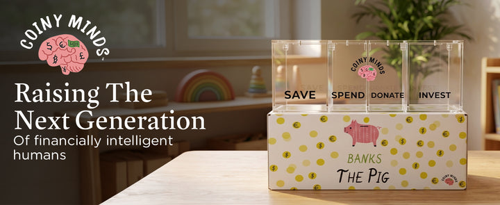 Coiny Minds: raising the next generation of financially intelligent humans. The four-compartment clear acrylic bank stands on its Banks the Pig gift box in a sunlit playroom.
